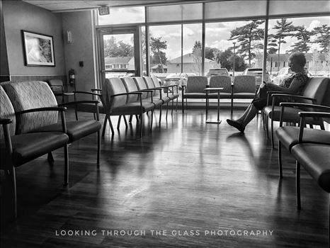 Silhouette of a woman down in black and white in a hospital waiting room. 